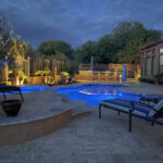A desert landscaped yard in Arizona featuring a travertine pool deck.